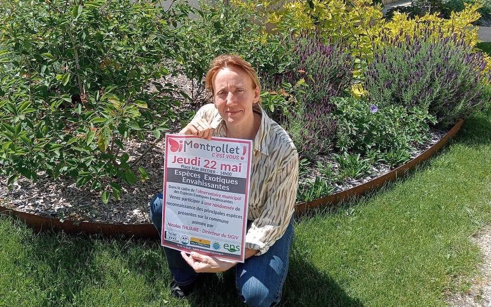 Céline Boutaud, adjointe au maire, avec l’affiche de la randonnée devant un massif fleuri (photo Charente Libre)