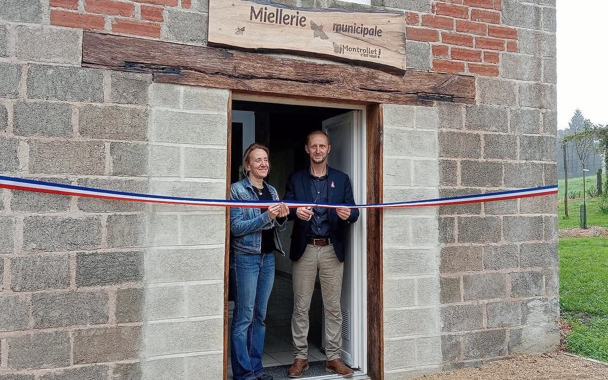 Céline Boutaud et Benoît Savy coupent le ruban tricolore sous l’enseigne de la miellerie municipale (photo Charente Libre)
