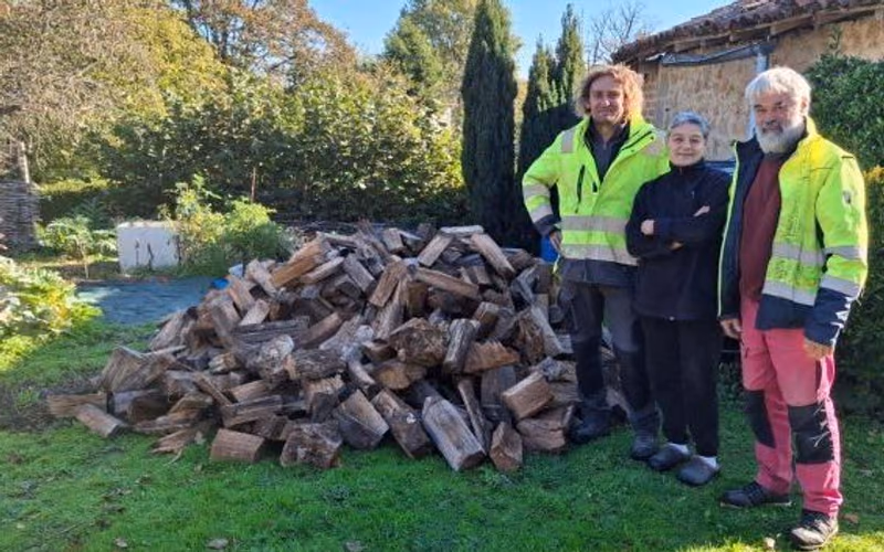 Les deux agents communaux et une bénéficiaire devant le bois livré (photo Gaëlle Pinaud, L’Avenir Le Confolentais)