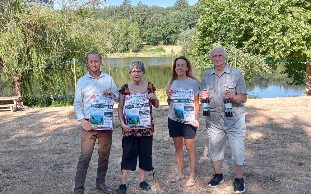Quatre organisateurs tenant l’affiche de la soirée au bord de l’étang communal (photo Charente Libre)